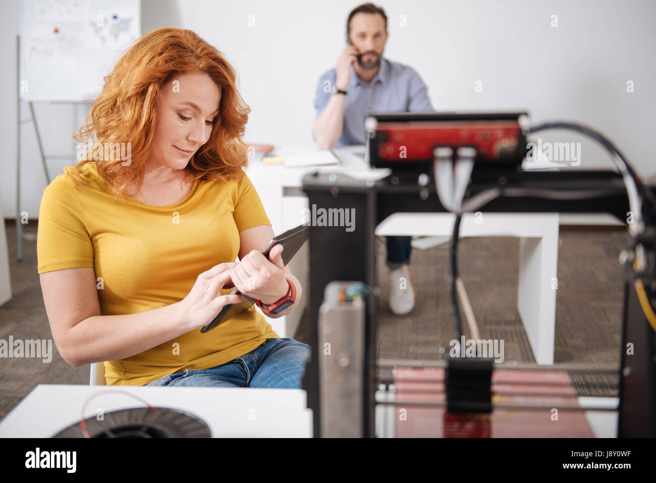 Freudige positive Frau arbeitet auf einem tablet Stockfoto