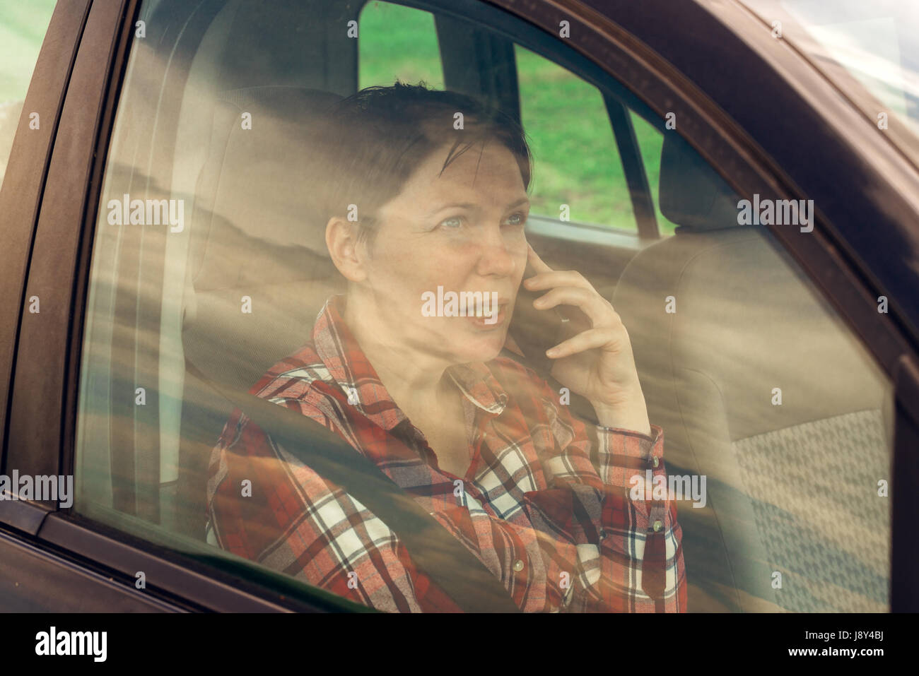 Besorgt Frau am Handy im Auto, betroffene Erwachsene kaukasischen weibliche Person während Telefongespräch Stockfoto