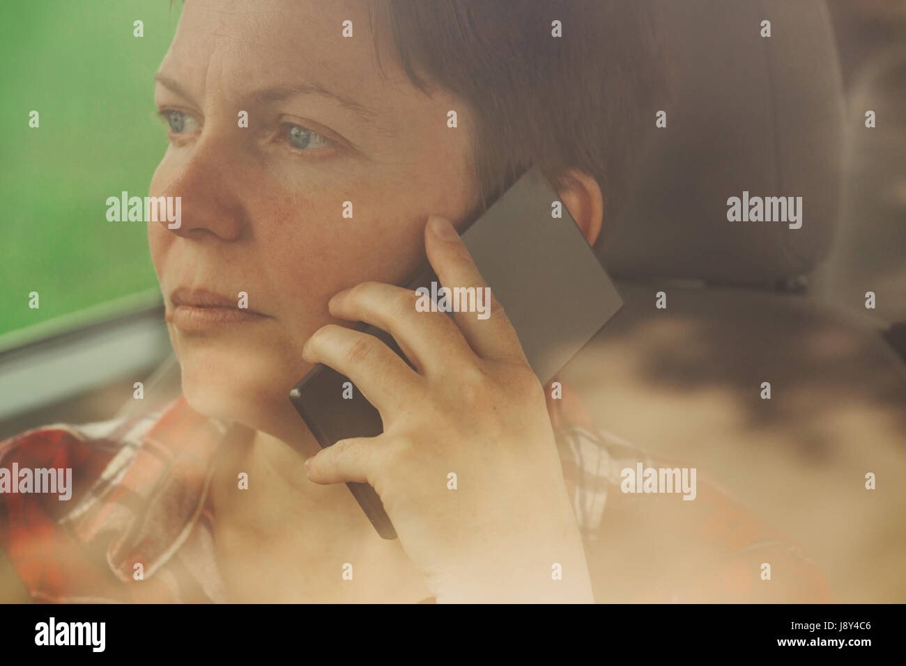 Besorgt Frau am Handy im Auto, betroffene Erwachsene kaukasischen weibliche Person während Telefongespräch Stockfoto