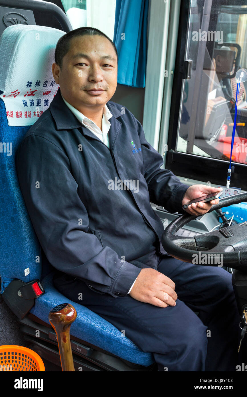 Guilin, China.  Busfahrer mit Handy. Stockfoto