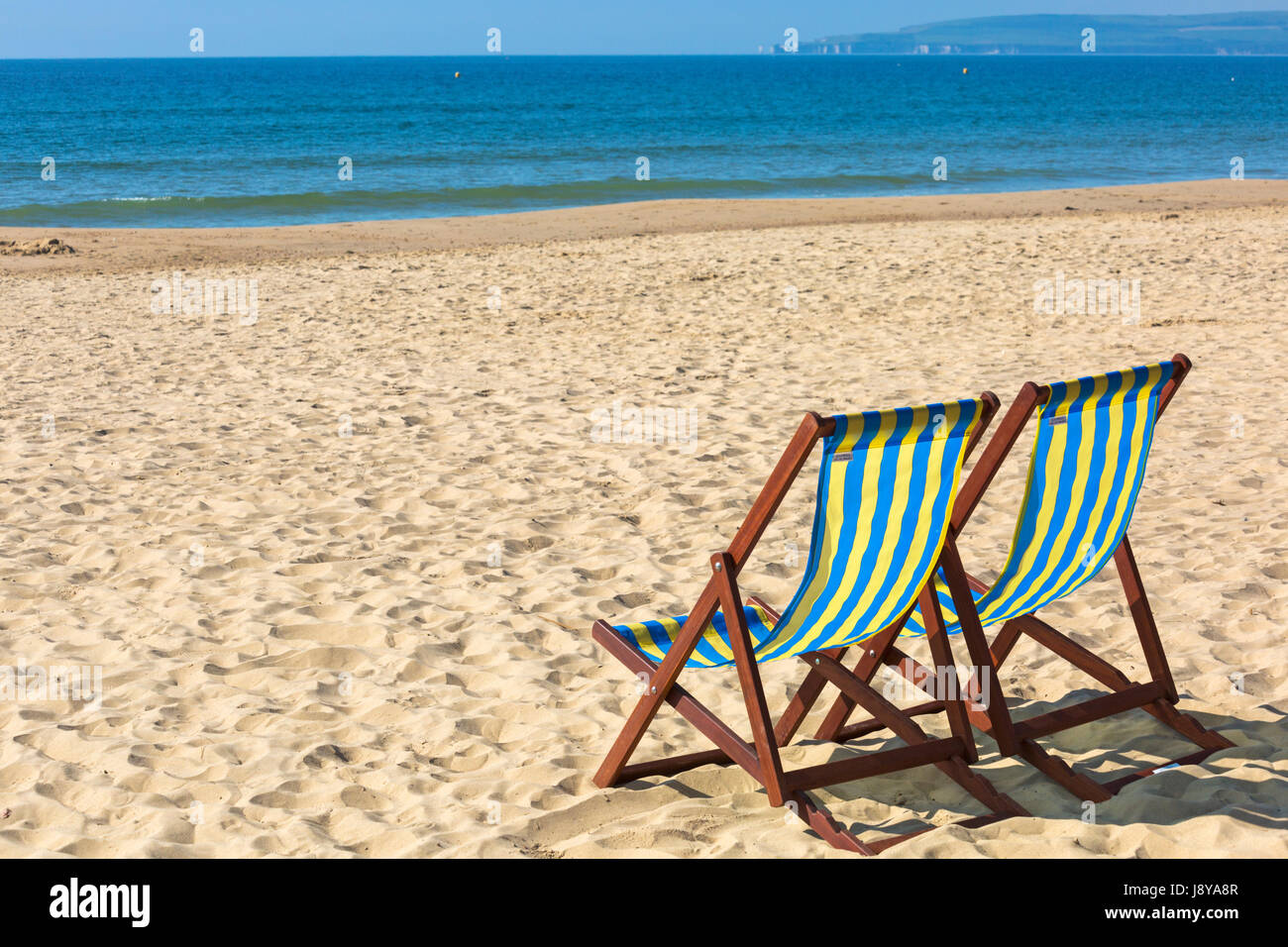 Zwei leere Liegestühle am Strand von Bournemouth im Mai Stockfoto