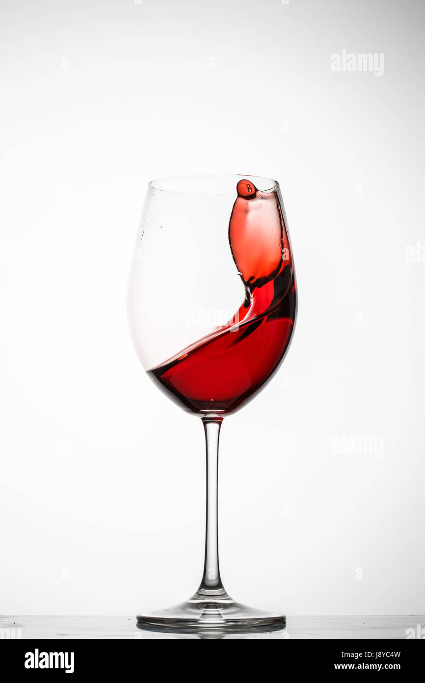 Rotwein Spritzer in einem Glas auf weißem Hintergrund Stockfoto