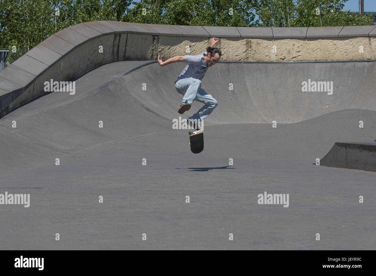 Ein Skateboarder Ausführung einen Kickflip in der Luft Stockfoto