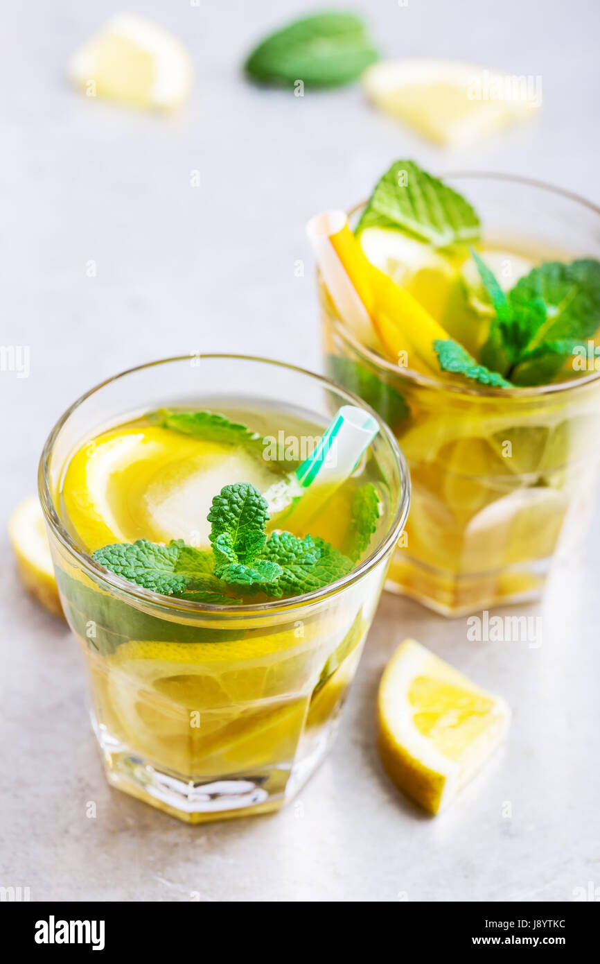 Hausgemachter Eistee Zitrone süßen Tee mit Minze auf grauen Leuchttisch, köstliche Sommer-Erfrischungsgetränk Stockfoto
