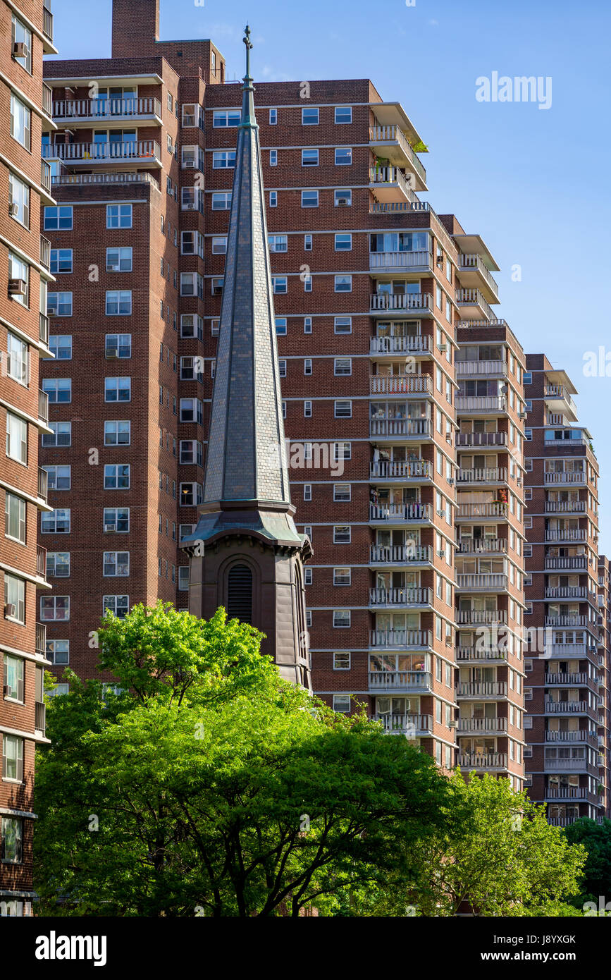 Der Turm der Kirche von der Heiligen Apostel im Gegensatz zu den Gebäude-Terrassen der Penn Süd in Chelsea im Sommer. Manhattan, New York City Stockfoto