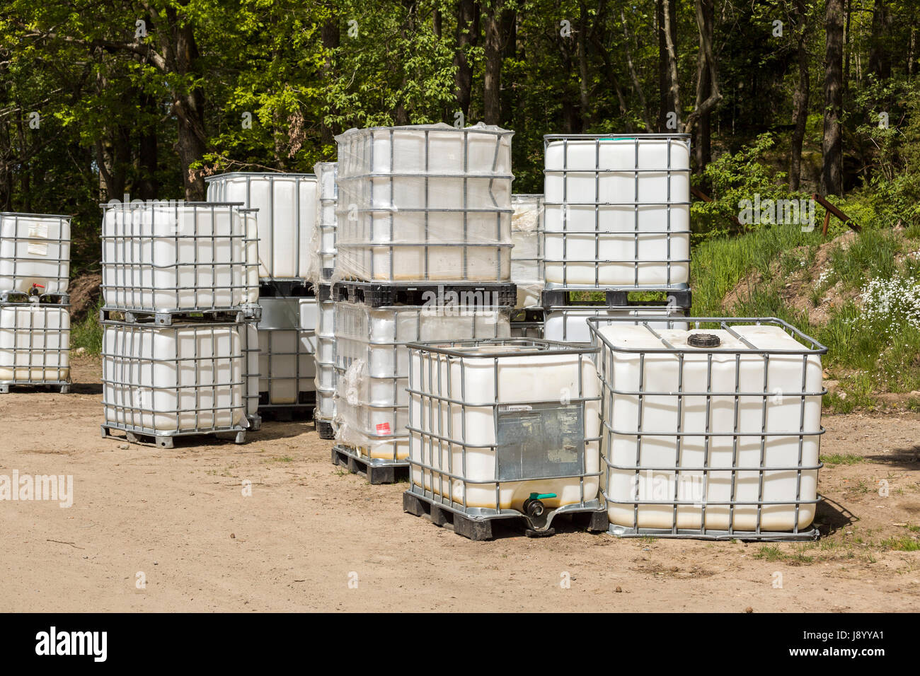 Viele neue Kunststoff eingesperrten IBC Intermediate Bulk Container im Freien Model Release: Nein Property Release: Nein. Stockfoto