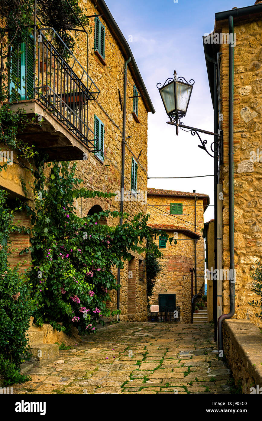 Casale Marittimo alte Steindorf in der Maremma am Sonnenuntergang. Malerischen blumige Straße und traditionellen Häusern. Toskana, Italien Europa. Stockfoto