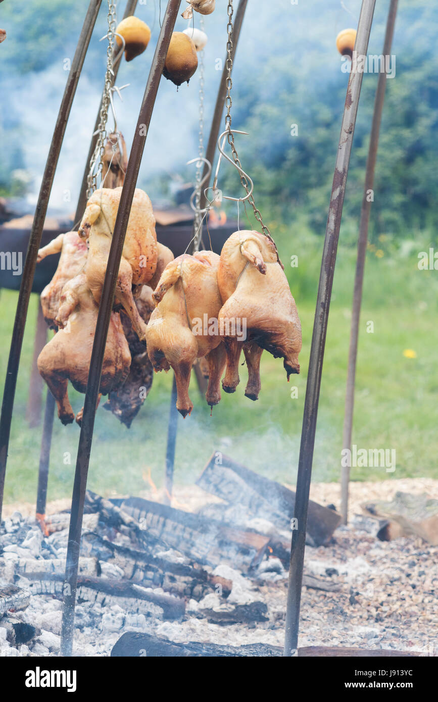 Argentinische Feuer Grube Kochen Hähnchen und Lamm in Daylesford Organic Farm-Sommerfest. Daylesford, Cotswolds, Gloucestershire, England Stockfoto