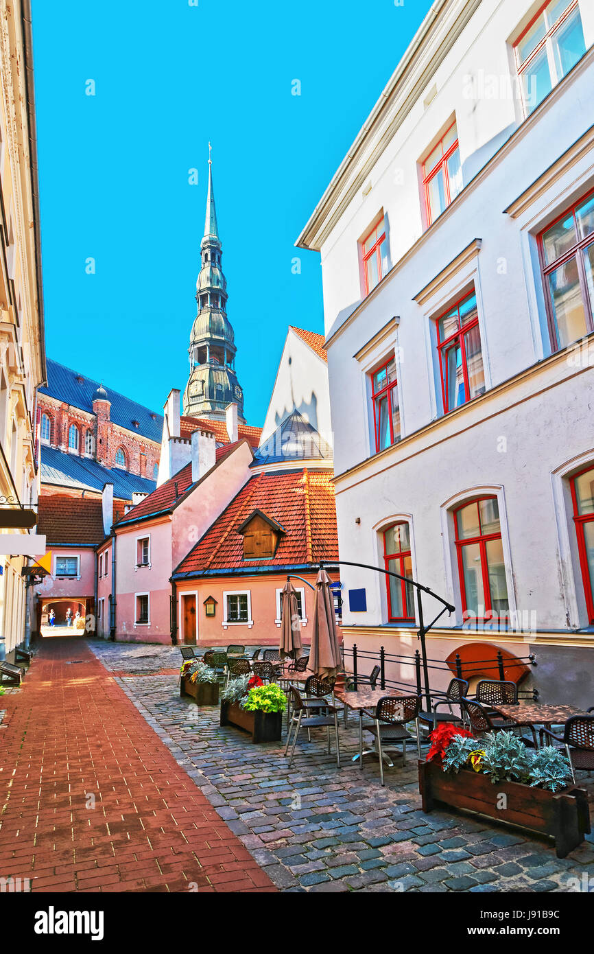 Straßencafé und Turm von St. Peter Church in der historischen Mitte in der Altstadt von Riga, Lettland. Stockfoto