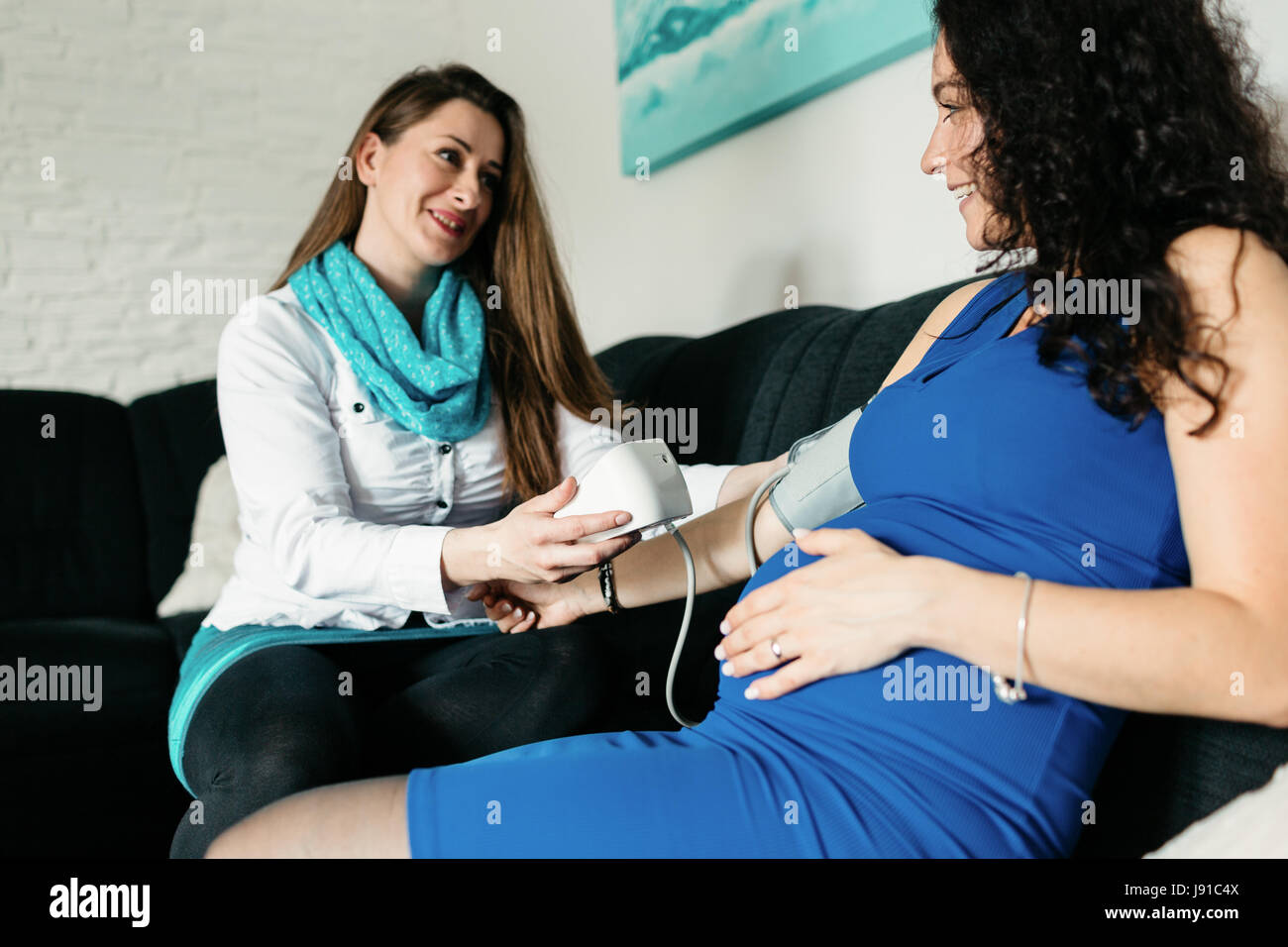 Hebamme Blutdruck Messen Einer Schwangeren Frau Stockfotografie - Alamy