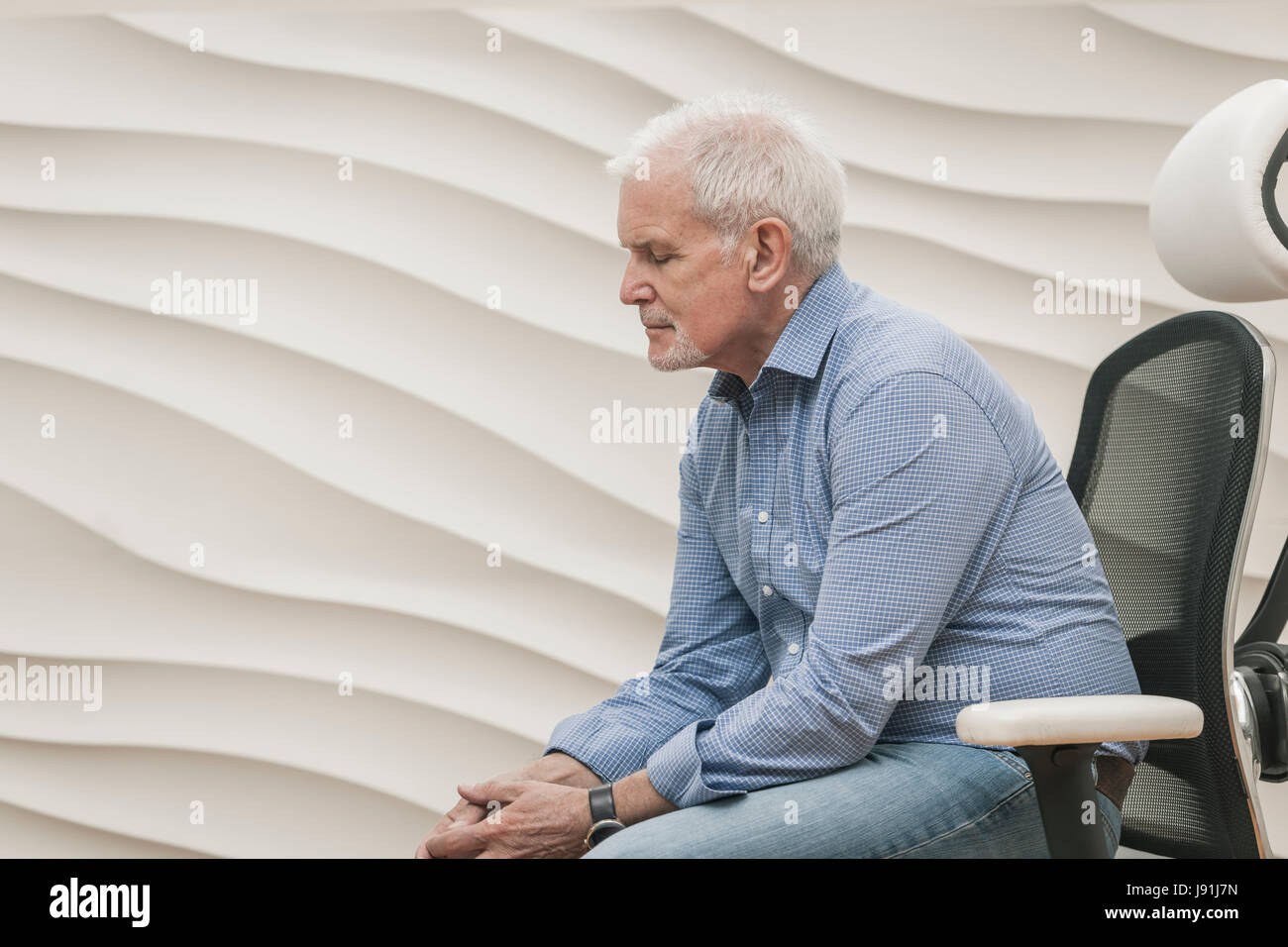 ältere Mann sitzt in Luxus Bürostuhl Stockfoto