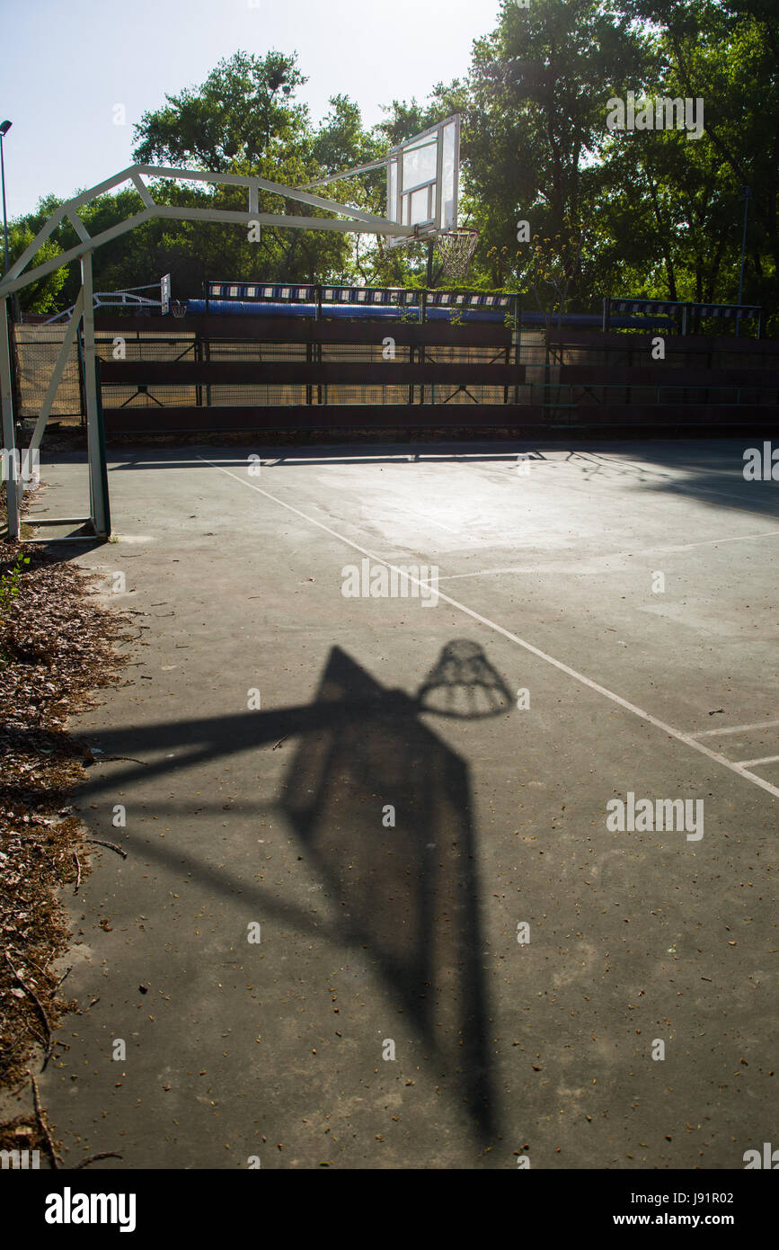 Einsame Basketballkorb auf leichten blauen Asphalt Platz im Schulhof Stockfoto