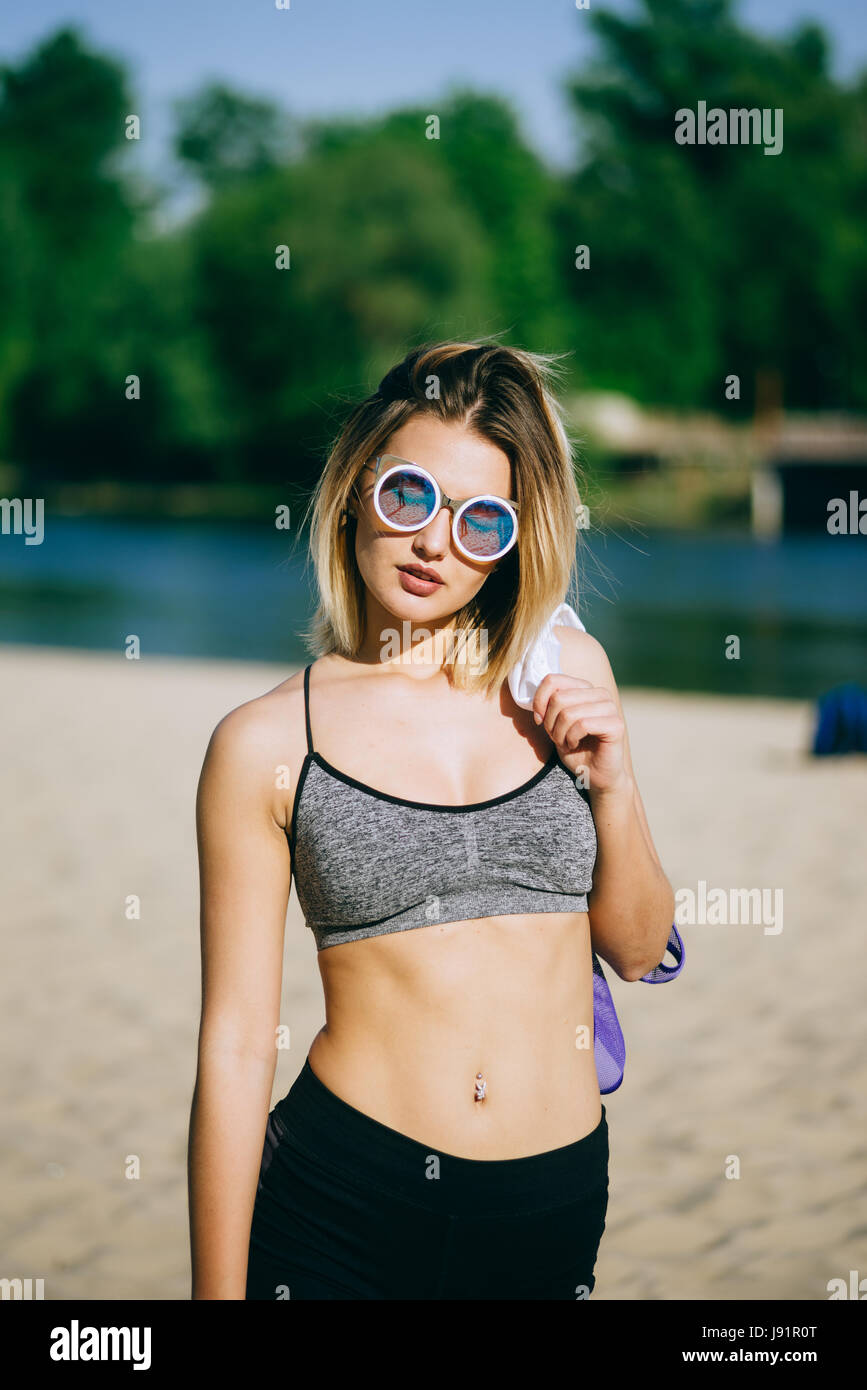 Schöne Blondine sehr sexy Pose für die Kamera in einem öffentlichen Strand nach dem Training mit sportlichen look Stockfoto