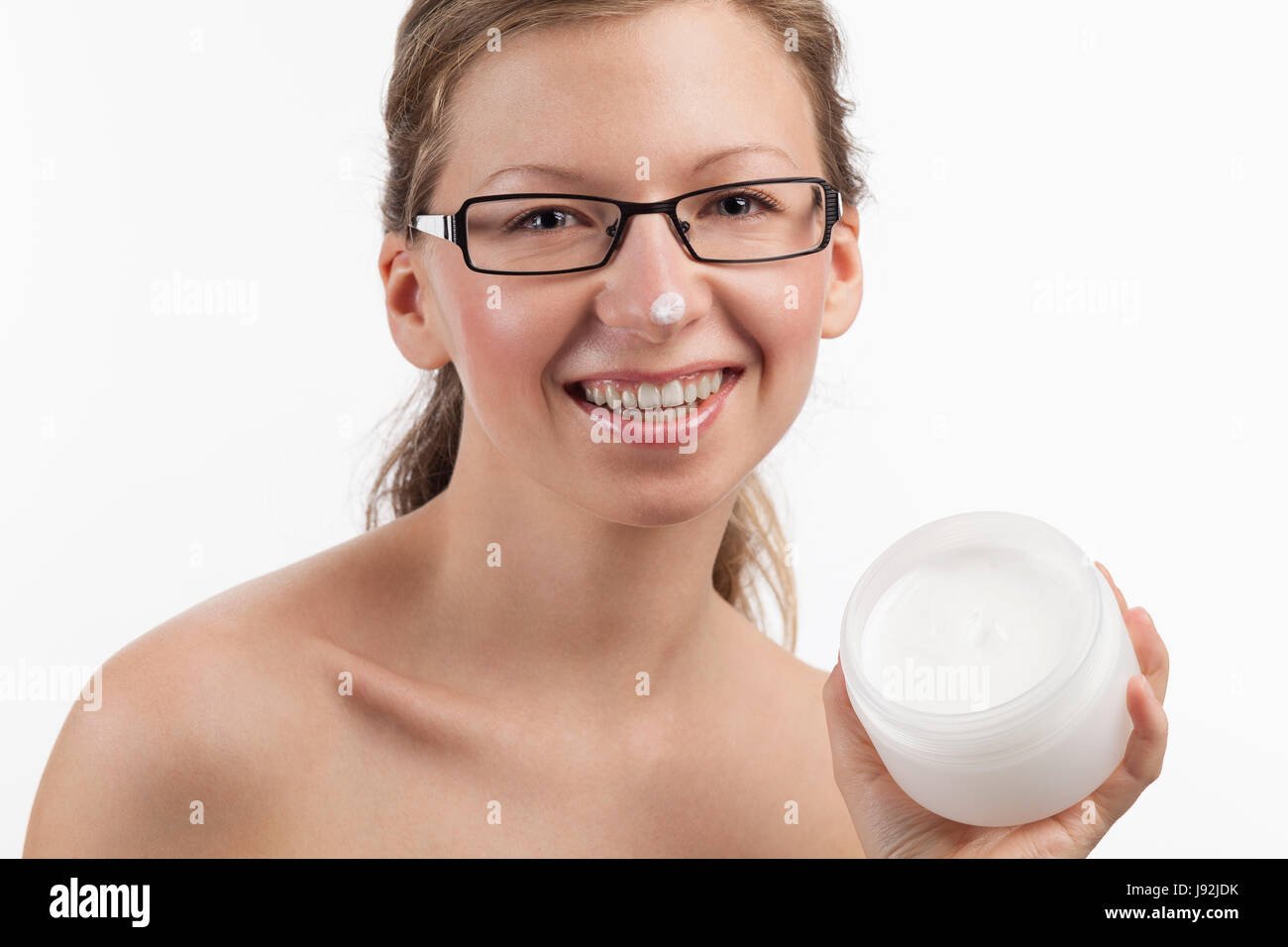 Lachende Frau mit einem kosmetischen Produkt in der hand Stockfoto