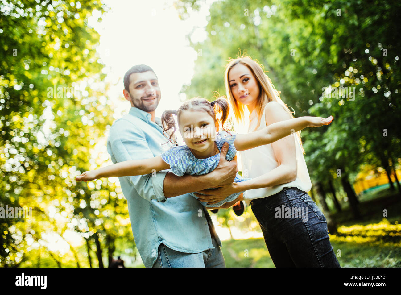 Glückliche Familie mit einem Kind Spaß zusammen im Sommer Stadtpark Stockfoto