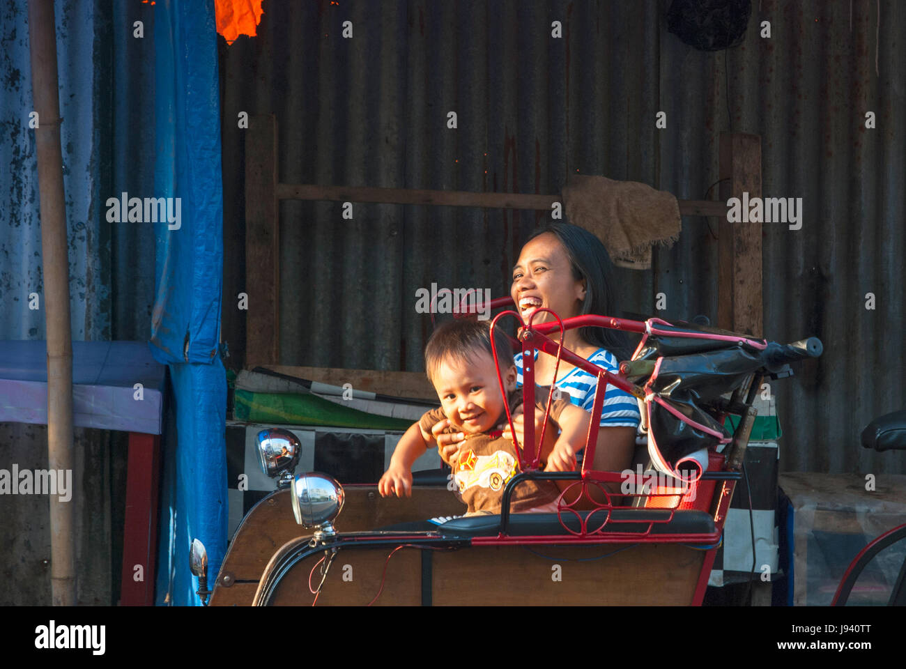 YOGYAKARTA, Indonesien - 15.September: Indonesische Frau und ihr Sohn genießen eine Fahrt mit der Rikscha in Yogyakarta, Indonesien am 15. September 2014. Stockfoto