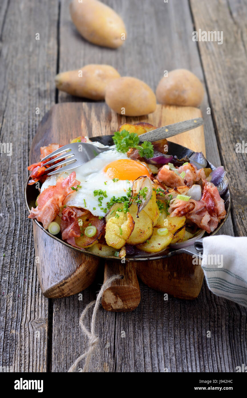 Bauernfrühstück mit Bratkartoffeln, Spiegelei und Speck in einer ...