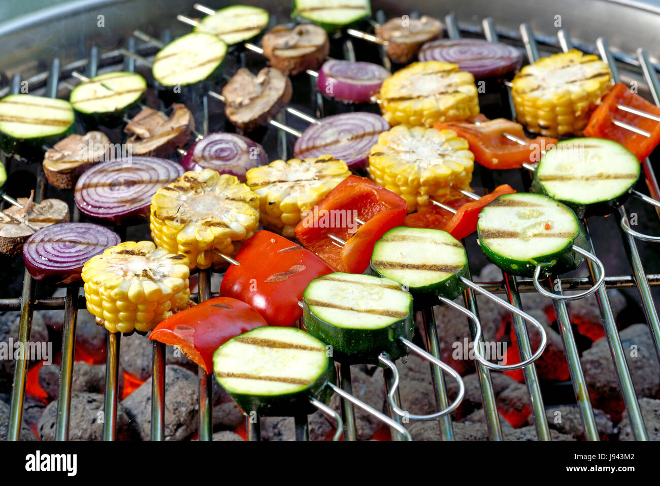 Spieße mit gemischtem Gemüse auf heißen Grill Holzkohle Briketts Stockfoto