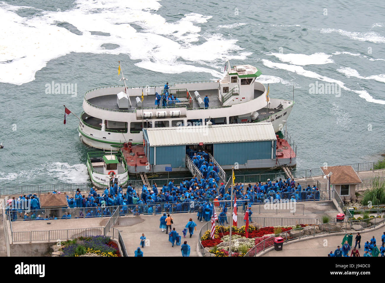 Touristen in blauen Regenmäntel einsteigen in das Mädchen des Nebels in Niagara Falls, Kanada. Stockfoto