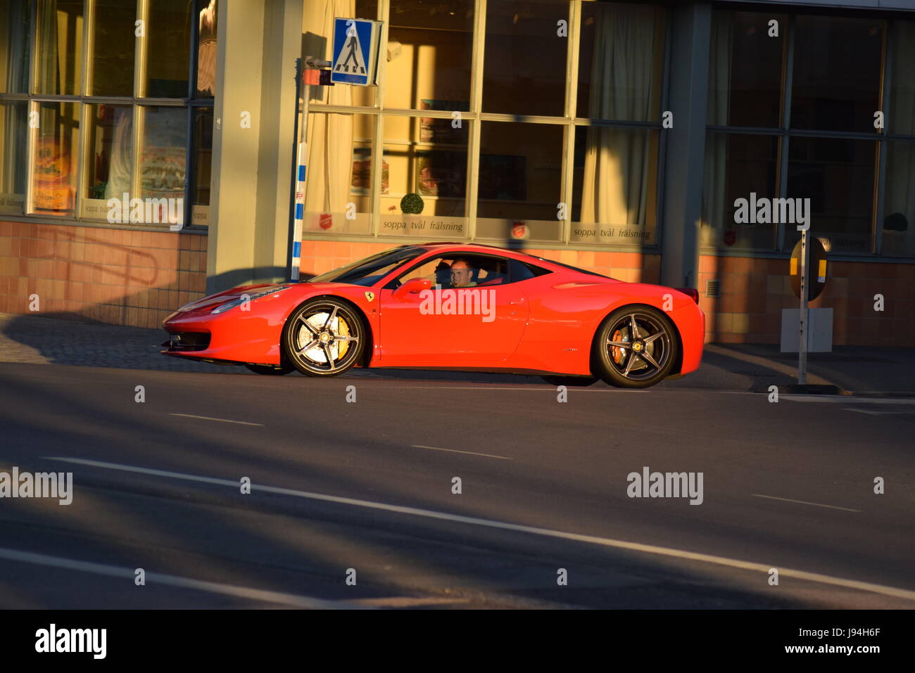 Ein Ferrari Fahrt durch die Straßen am Abend Stockfoto