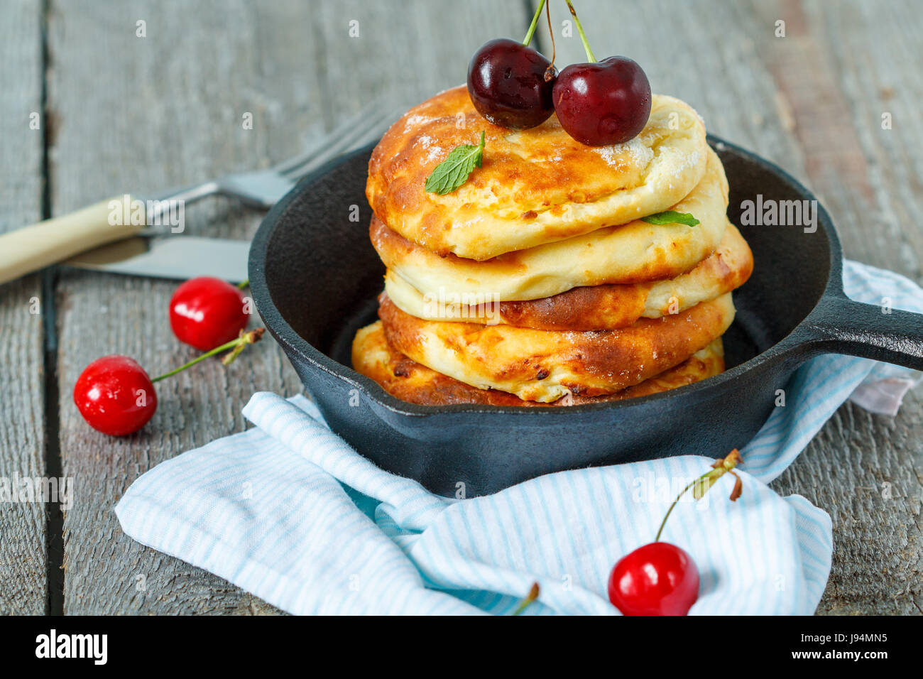 Hausgemachter Hüttenkäse Pfannkuchen mit Kirschen in einer gusseisernen ...