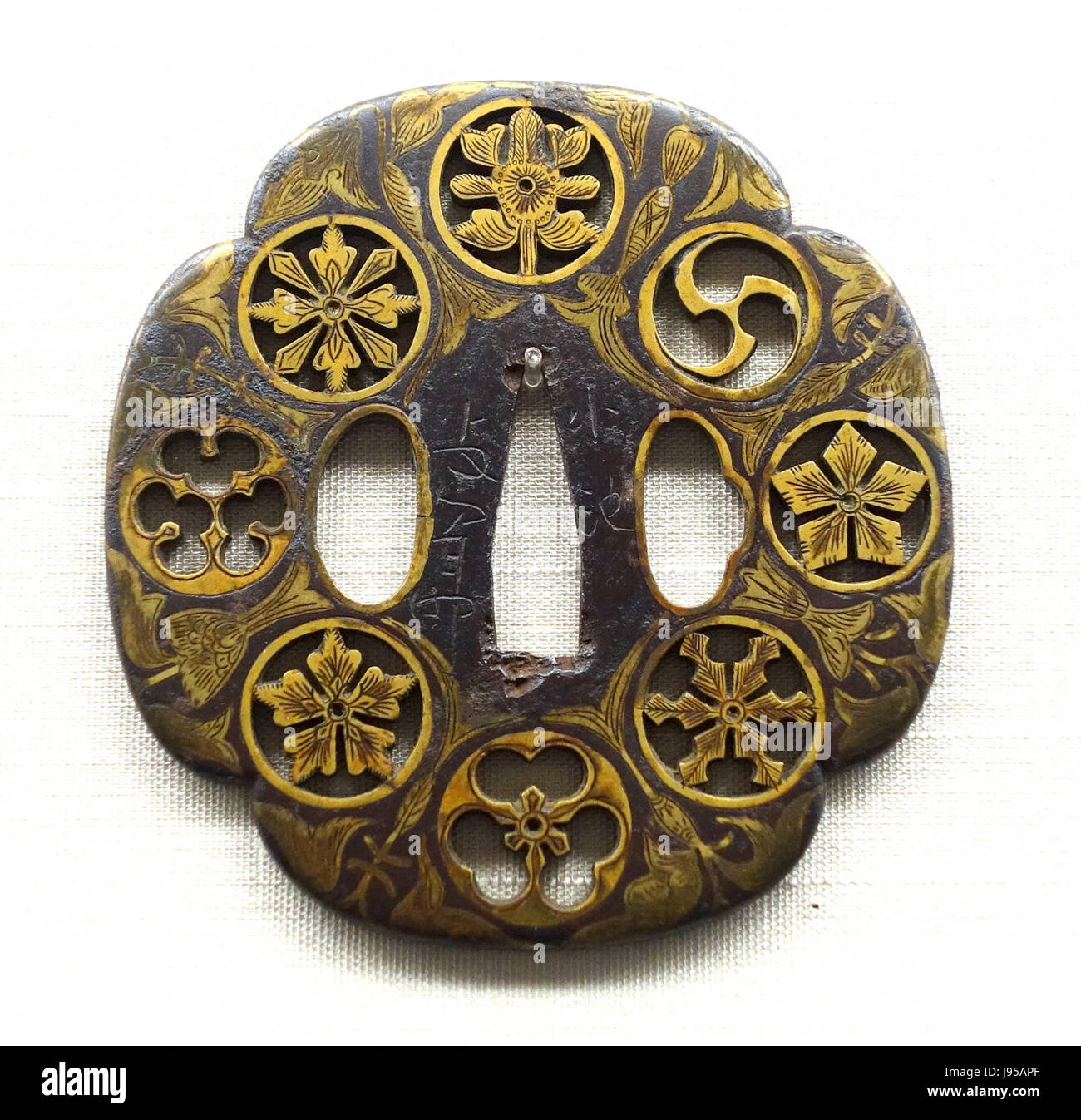 Dieser Schwertschutz, der von Naomasa während der Edo-Zeit Japanâ 17. Jahrhundert geschaffen wurde, weist komplizierte Familienwappen in durchbrochenem Design auf. Es ist im Tokyo National Museum untergebracht und zeigt die Kunstfertigkeit der japanischen Metallverarbeitung. Stockfoto