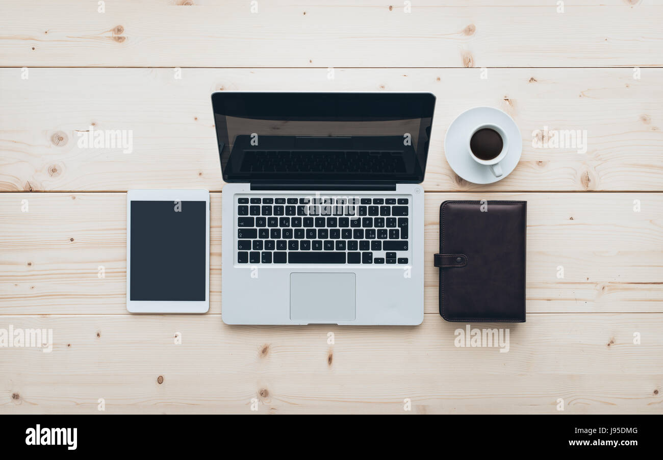 Minimale Büro Arbeitsbereich: Laptop, Tablet, Veranstalter und Kaffee auf einem hölzernen Schreibtisch flach legen Stockfoto