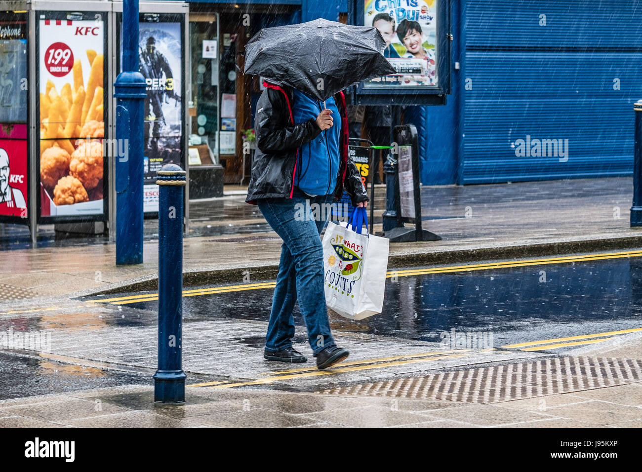 Aberystwyth Wales UK, Montag, 5. Juni 2017 UK Wetter: sintflutartigen Regen fällt auf Fußgänger bergende unter ihren Sonnenschirmen in Aberystwyth, Wales.  Nach Wochen aus trockenen und warmen Wetter Bedingungen deutlich geändert haben, mit der Woche voraus voraussichtlich sehr nass und windig, aber warm Foto © Keith Morris / Alamy Live News Stockfoto