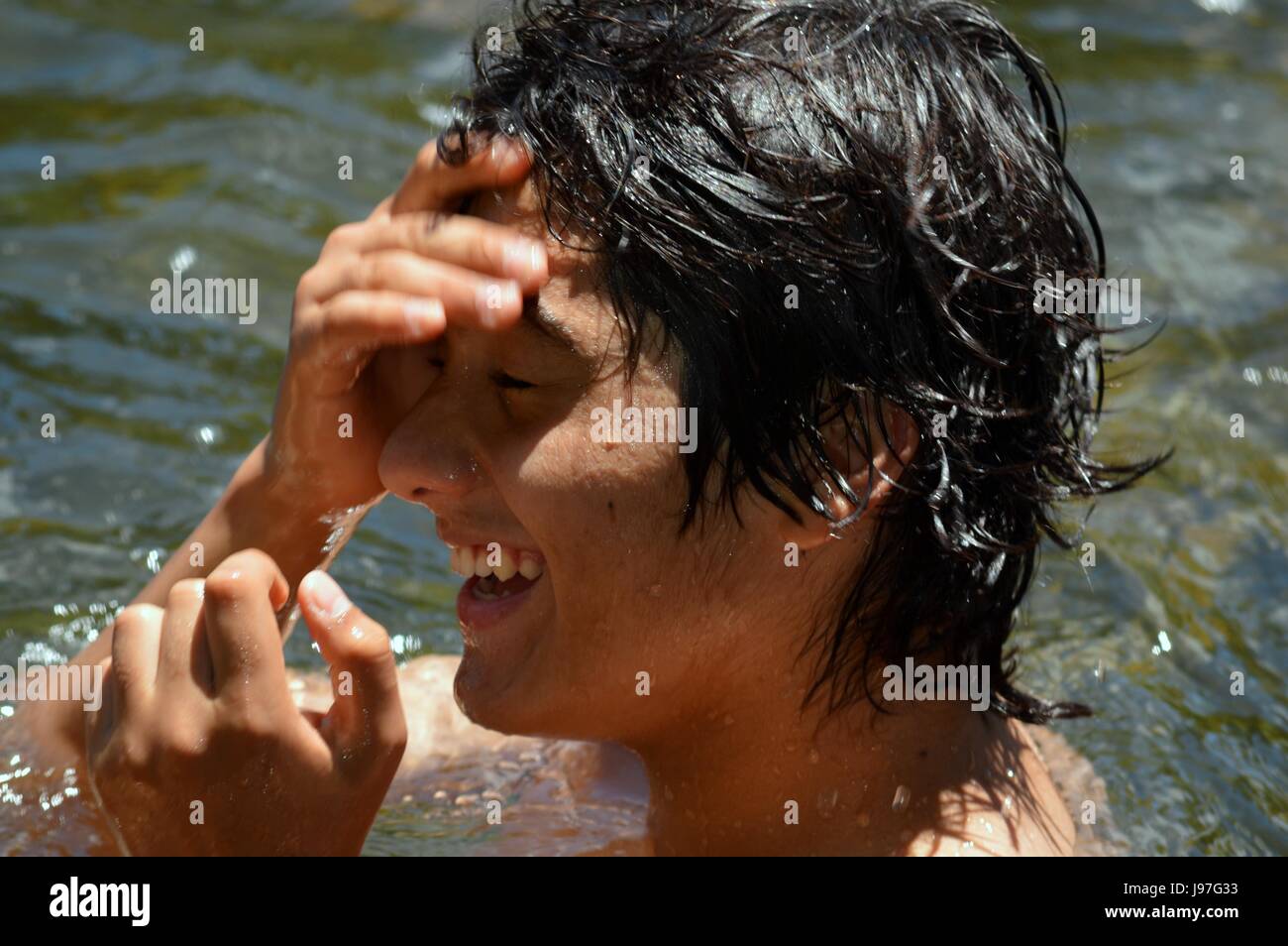 Junger Teenager genießt ein Bad im Fluss Calamuchita, Cordoba, Argentinien Stockfoto
