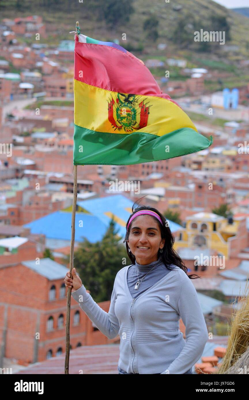 Schöne und glückliche Frau posiert mit der bolivianischen Flagge in Copacabana Stockfoto