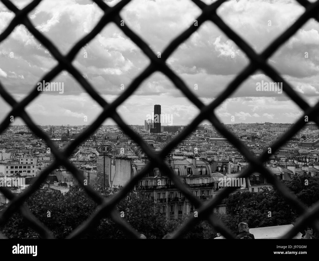 Paris-Skyline durch einen Zaun.  La Tour-Wolkenkratzer in der Ferne zu sehen. Bild kann als Metapher für die Paris-Abkommen-Klima-Abkommen gesehen werden. Stockfoto