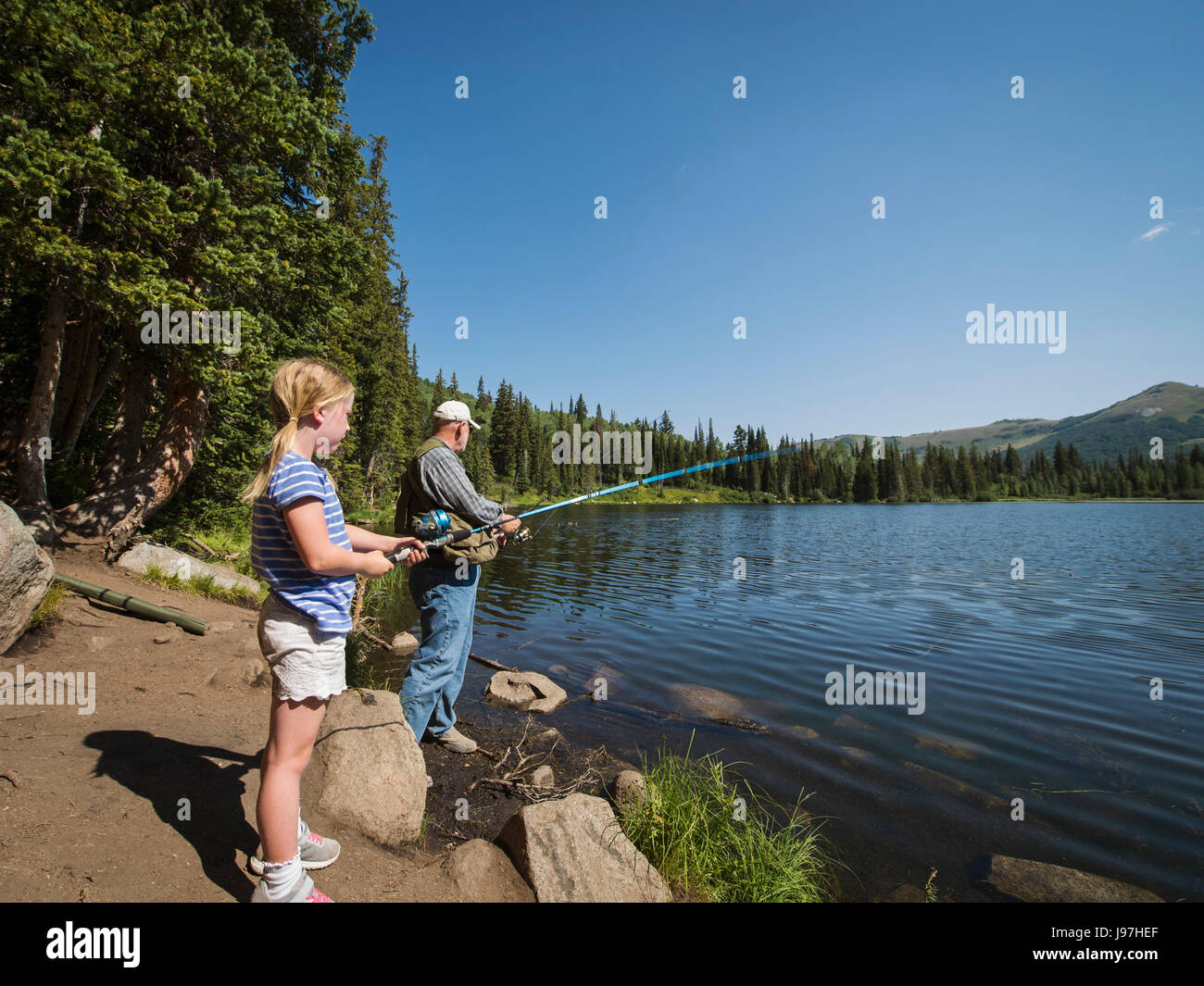 USA, Lake City, Utah Mädchen (4-5) mit Großvater Angeln im See Stockfoto