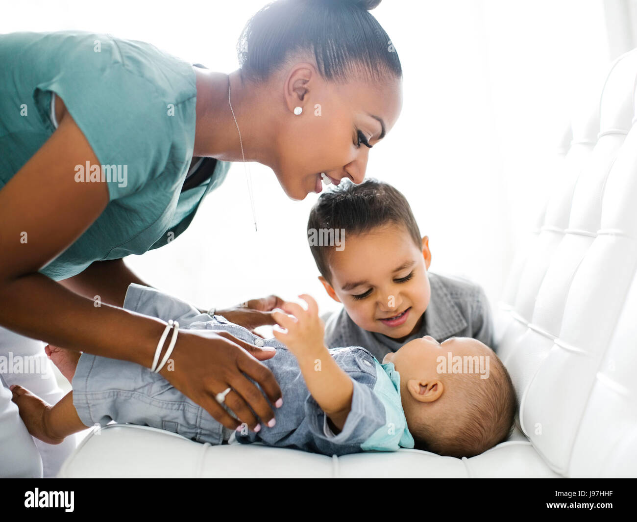 Mutter mit zwei Söhnen (2-5 Monate, 2-3) auf sofa Stockfoto