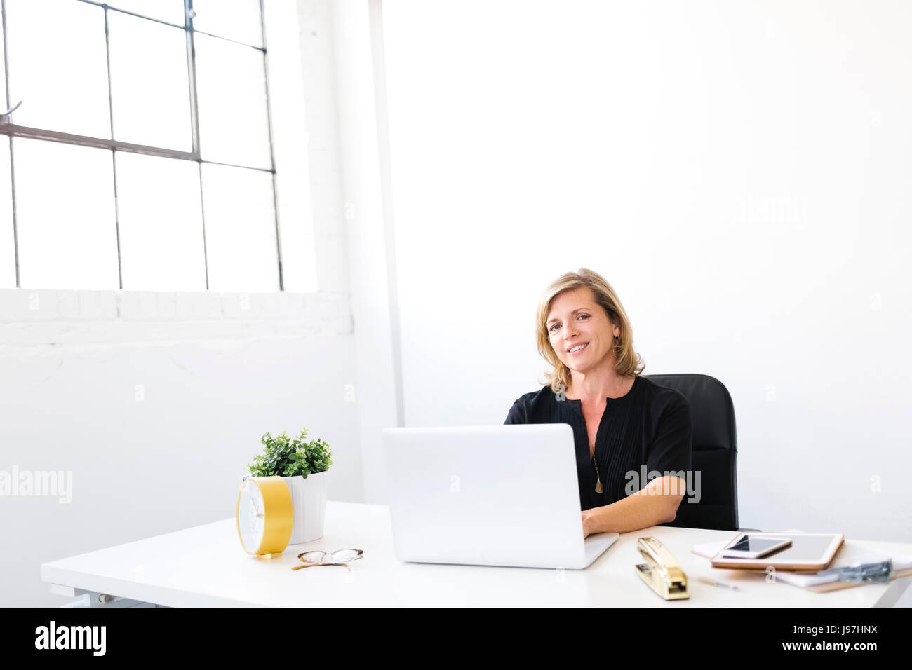 Frau mit Laptop, Blick in die Kamera Stockfoto