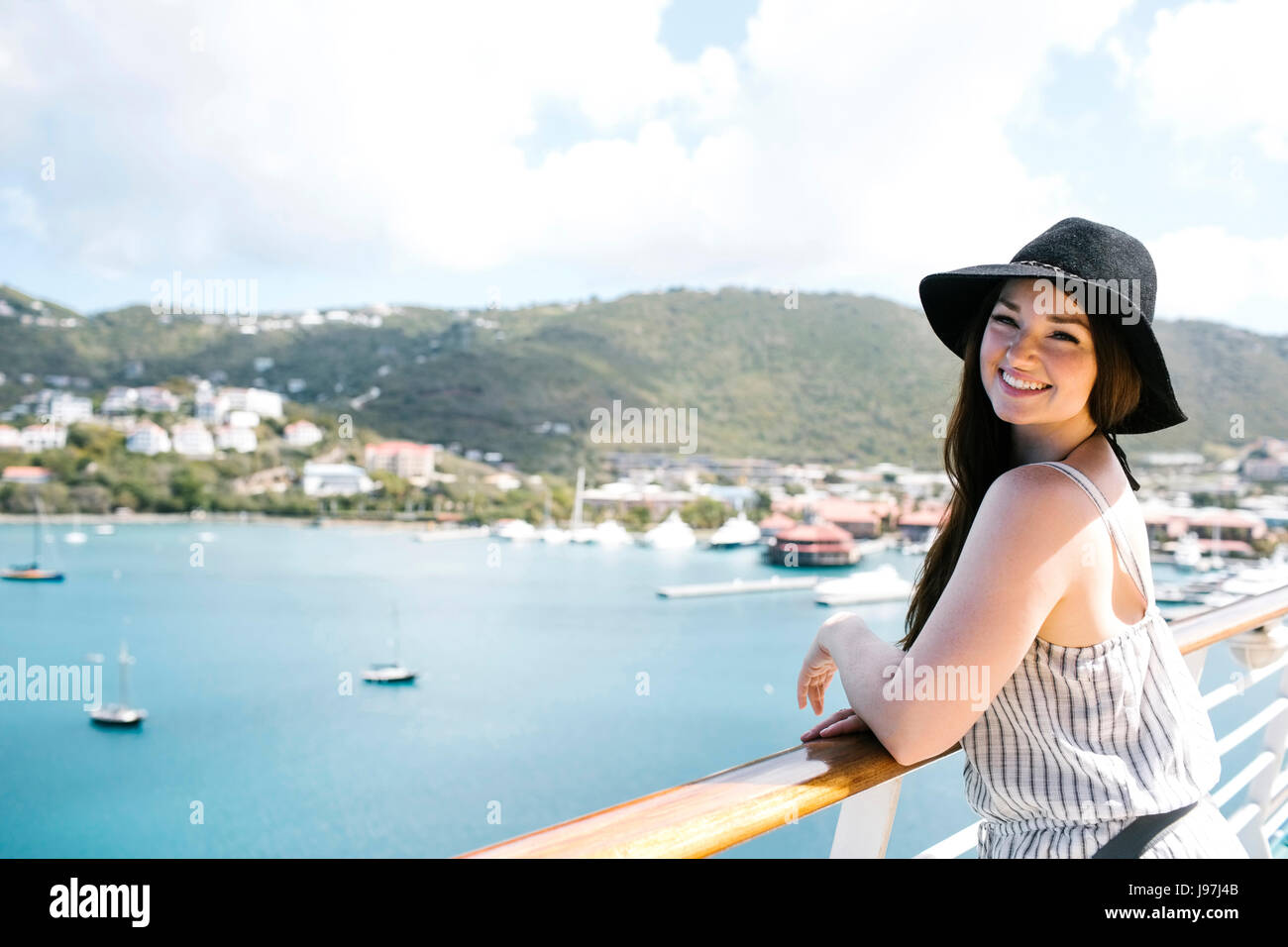USA, Virgin Islands, St. Thomas, Frau lehnt sich an die Reling und mit Blick auf Bucht Stockfoto