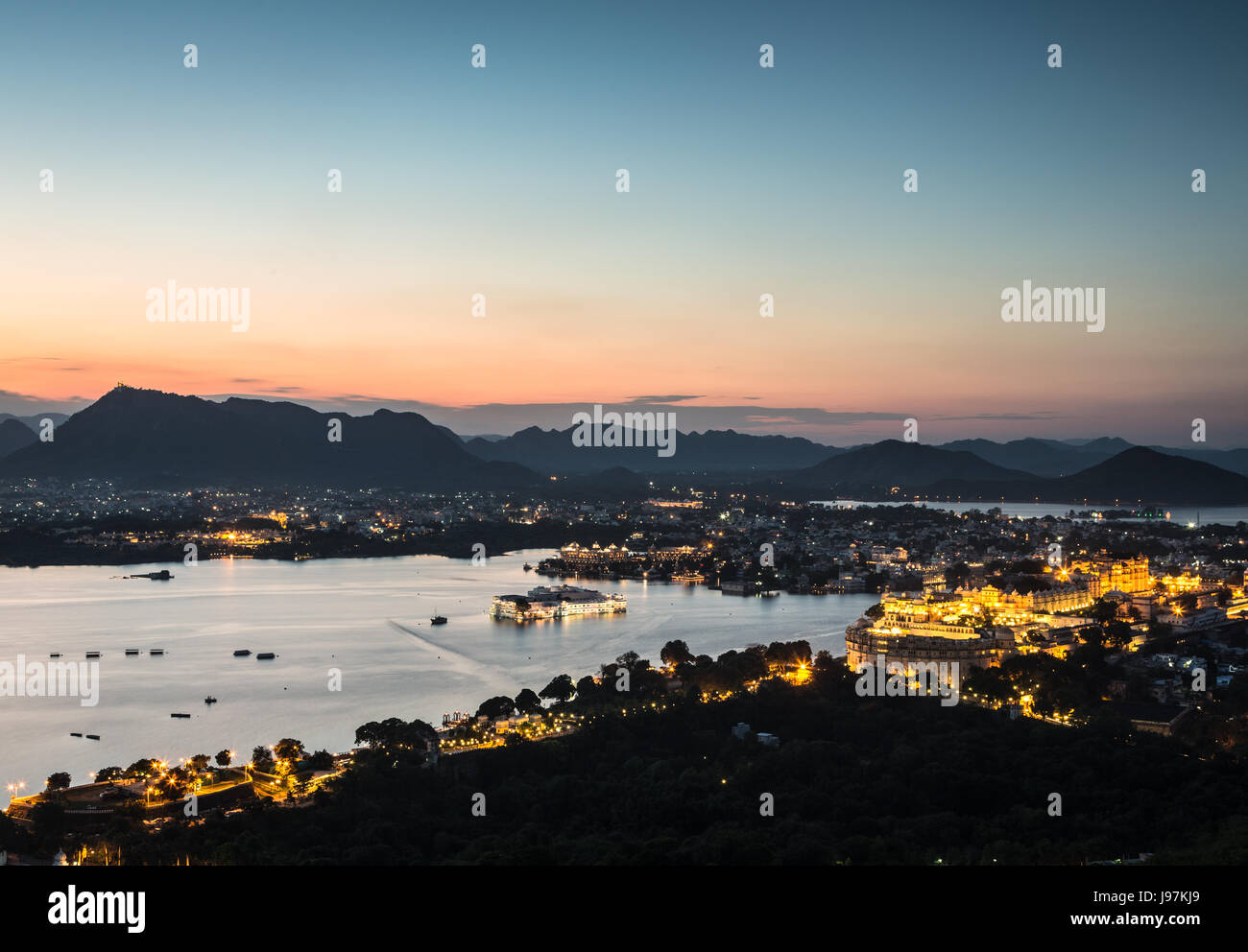 Sonnenuntergang über Paläste auf der Mitte des Pichola-See in Udaipur in der Nacht, Rajasthan, Indien Stockfoto