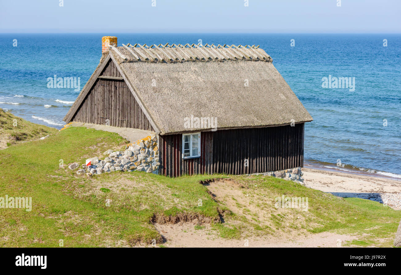 Havang Naturschutzgebiet, Schweden - 18. Mai 2017: ökologische Dokumentarfilm. Schwarz und alte Fischerei Hütte mit Strohdach und Kamin, neben dem Sandstrand Stockfoto