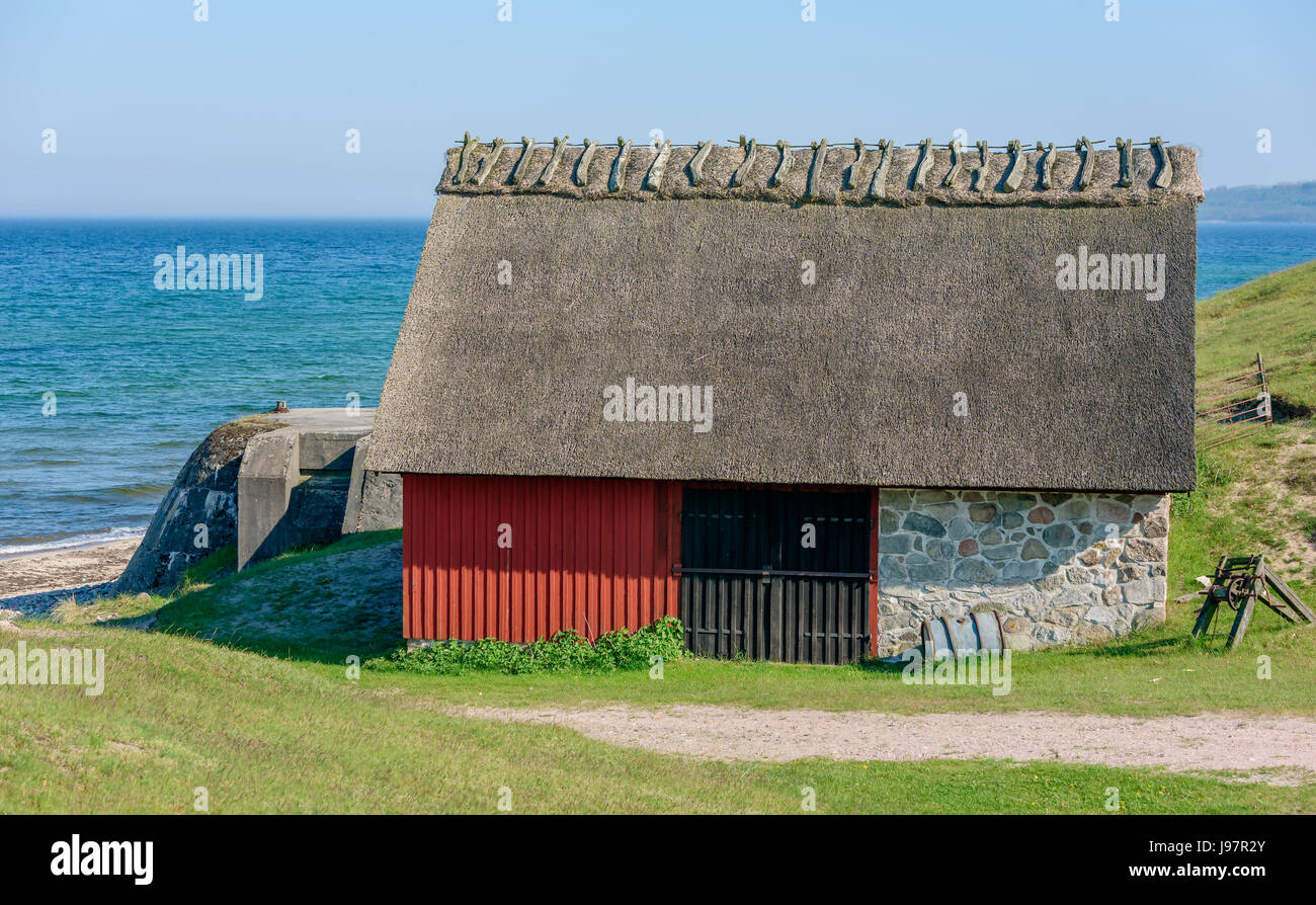 Havang Naturschutzgebiet, Schweden - 18. Mai 2017: ökologische Dokumentarfilm. Rot und alte Fischerei Hütte mit Strohdach direkt neben dem Sandstrand. Stockfoto