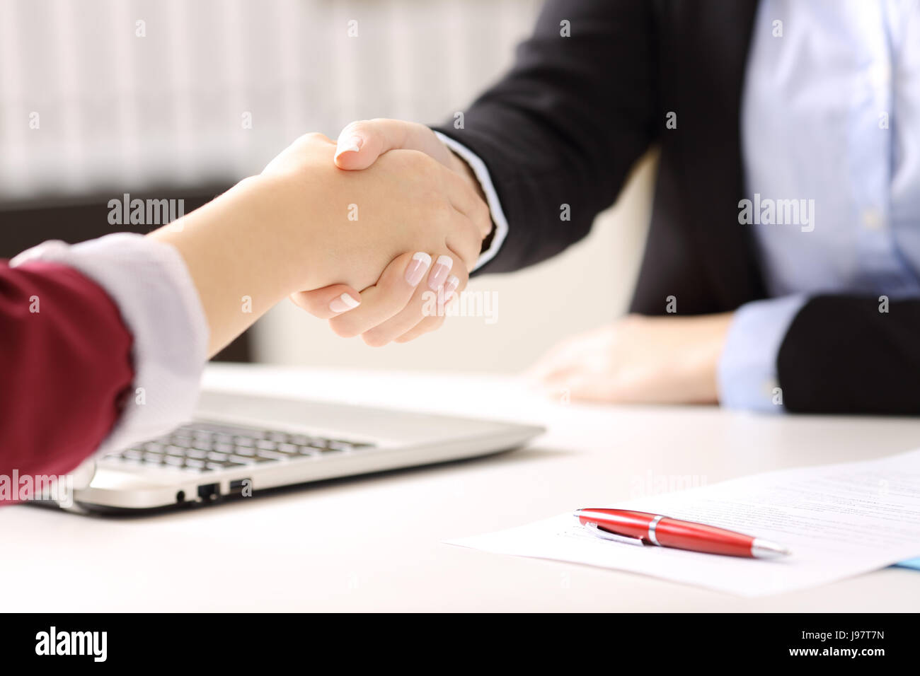 Nahaufnahme von zwei Geschäftsfrauen Hände Handshake nach einen deal zu schließen und Vertragsunterzeichnung in einen Schreibtisch mit einer Office-Hintergrund Stockfoto