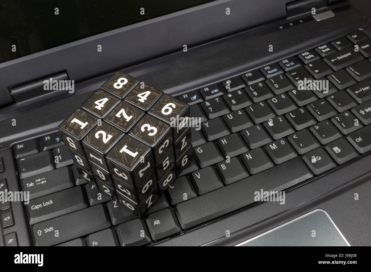 Würfel mit beweglichen Teilen, die auf jeder Seite gedruckten Zahlen als verschlüsselt werden können, platziert auf Laptop, Bild über Datensicherheit und Kryptographie Stockfoto