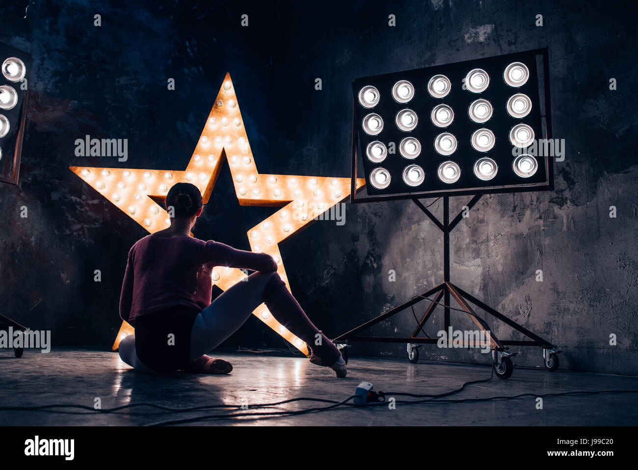 Ballett Tänzerin Übung vor einem beleuchteten Stern auf einem Dak-studio Stockfoto