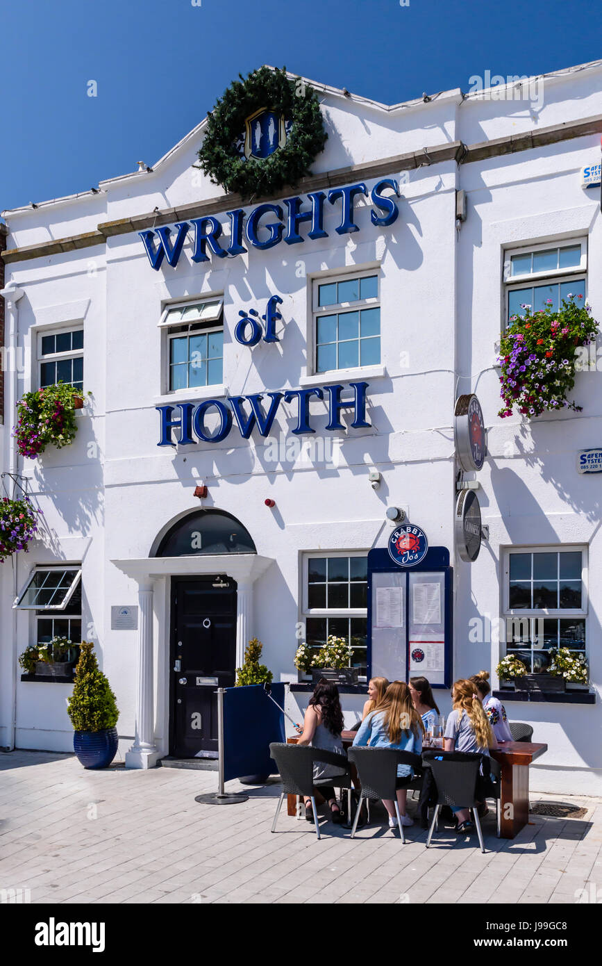 Menschen Essen und genießen Sie einen Drink in der Sonne vor einem Fischrestaurant in Howth, Dublin, Irland. Stockfoto