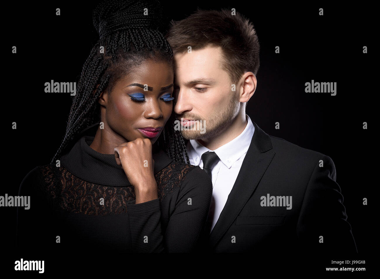 Porträt des multi-ethnischen romantisch zu zweit auf schwarzem Hintergrund hautnah. Stockfoto
