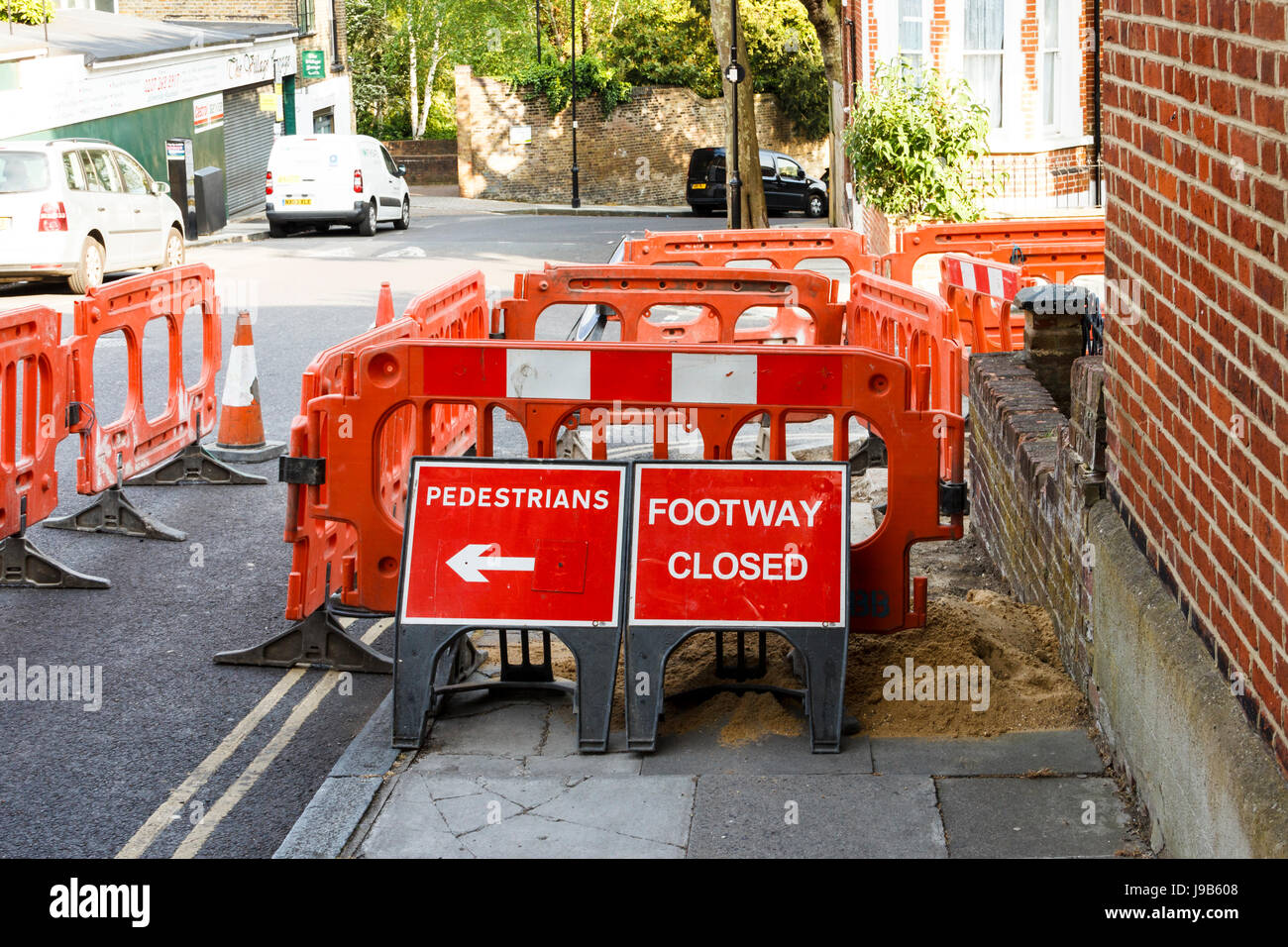 Rote und weiße Warnleuchte Marker, Kegel und Fechten, Fußweg für Reparaturen in Islington, London, UK geschlossen Stockfoto