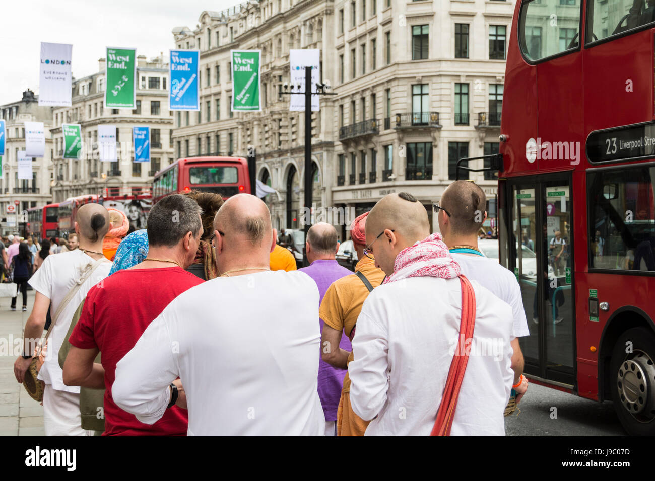 Hare-Krishna-Anhänger singen und tanzen in der Regent Street in central London, UK Stockfoto