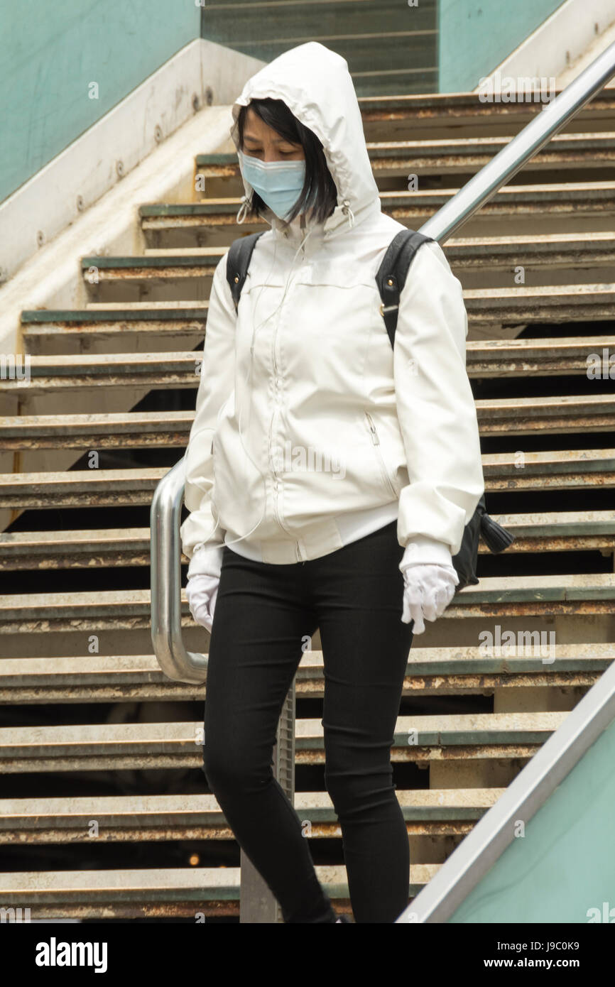 Eine Chinesin in London, die eine Gesichtsmaske trägt, um die Ausbreitung von Husten, Erkältungen und Viren zu verhindern Stockfoto