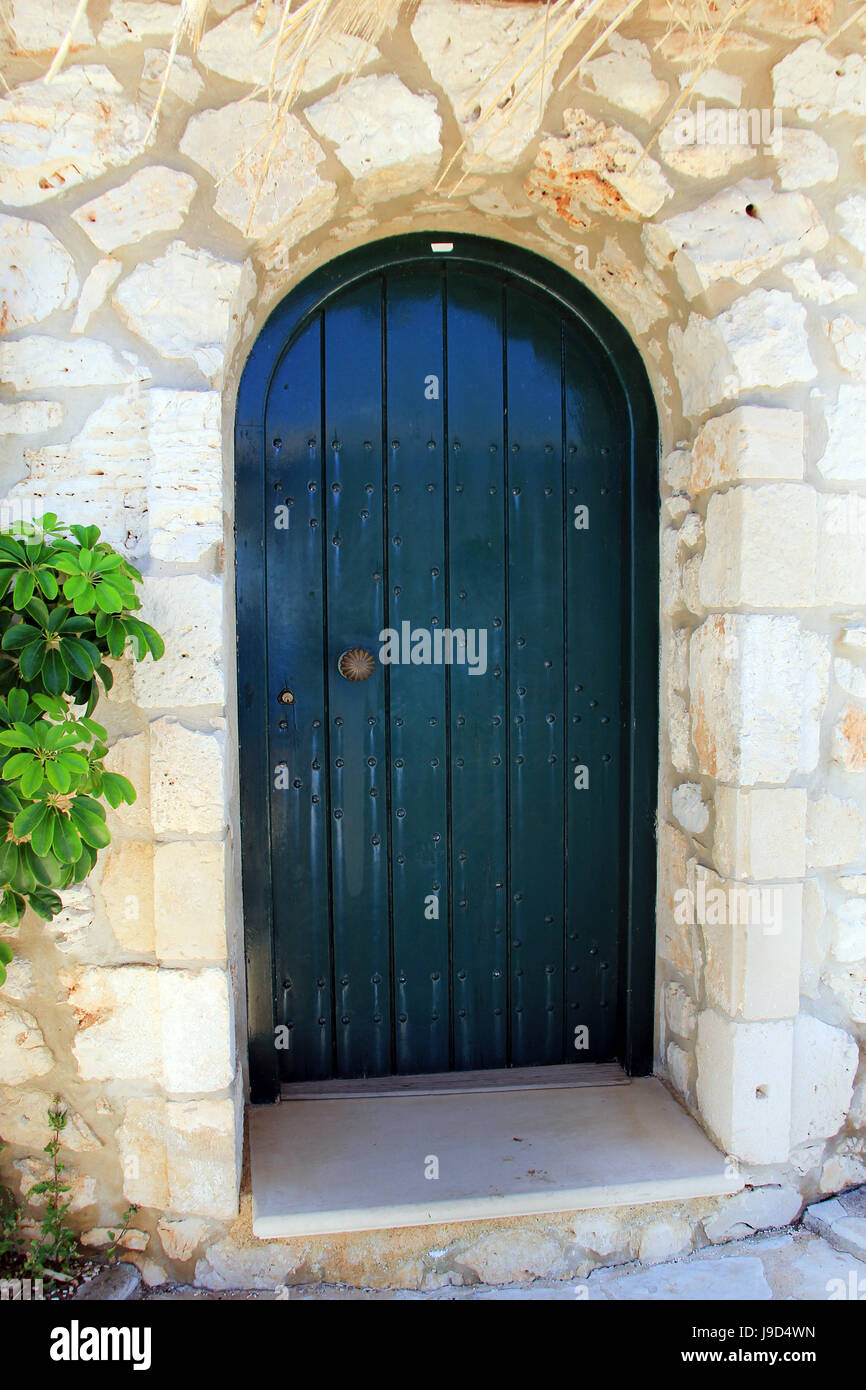 Alte Tür in Steinmauer an traditionelle Windmühle auf Griechenland Stockfoto