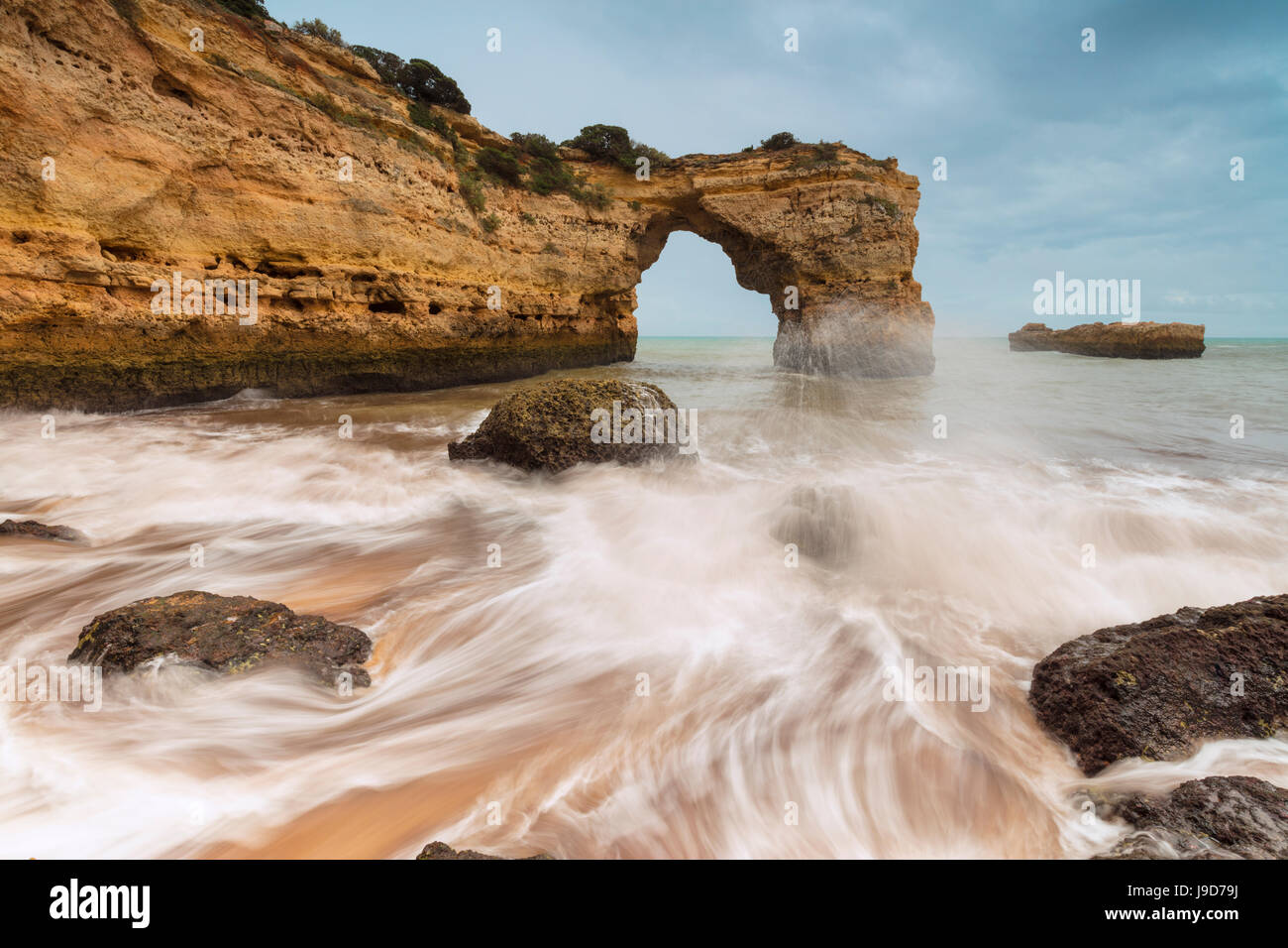 Wellen, die am Sandstrand umgeben von Klippen, Albandeira, Gemeinde Lagoa, Algarve, Portugal, Europa Stockfoto