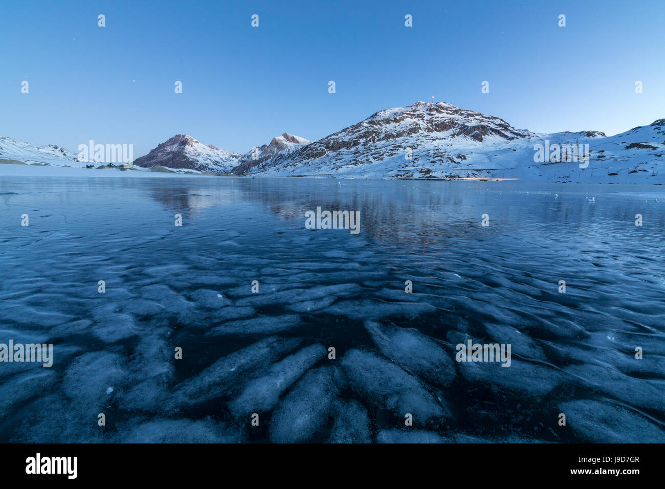 Die gefrorenen Lago Bianco umrahmt die blauen Lichter der Dämmerung,  Berninapass, Kanton Graubünden, Engadin, Schweiz, Europa Stockfotografie -  Alamy