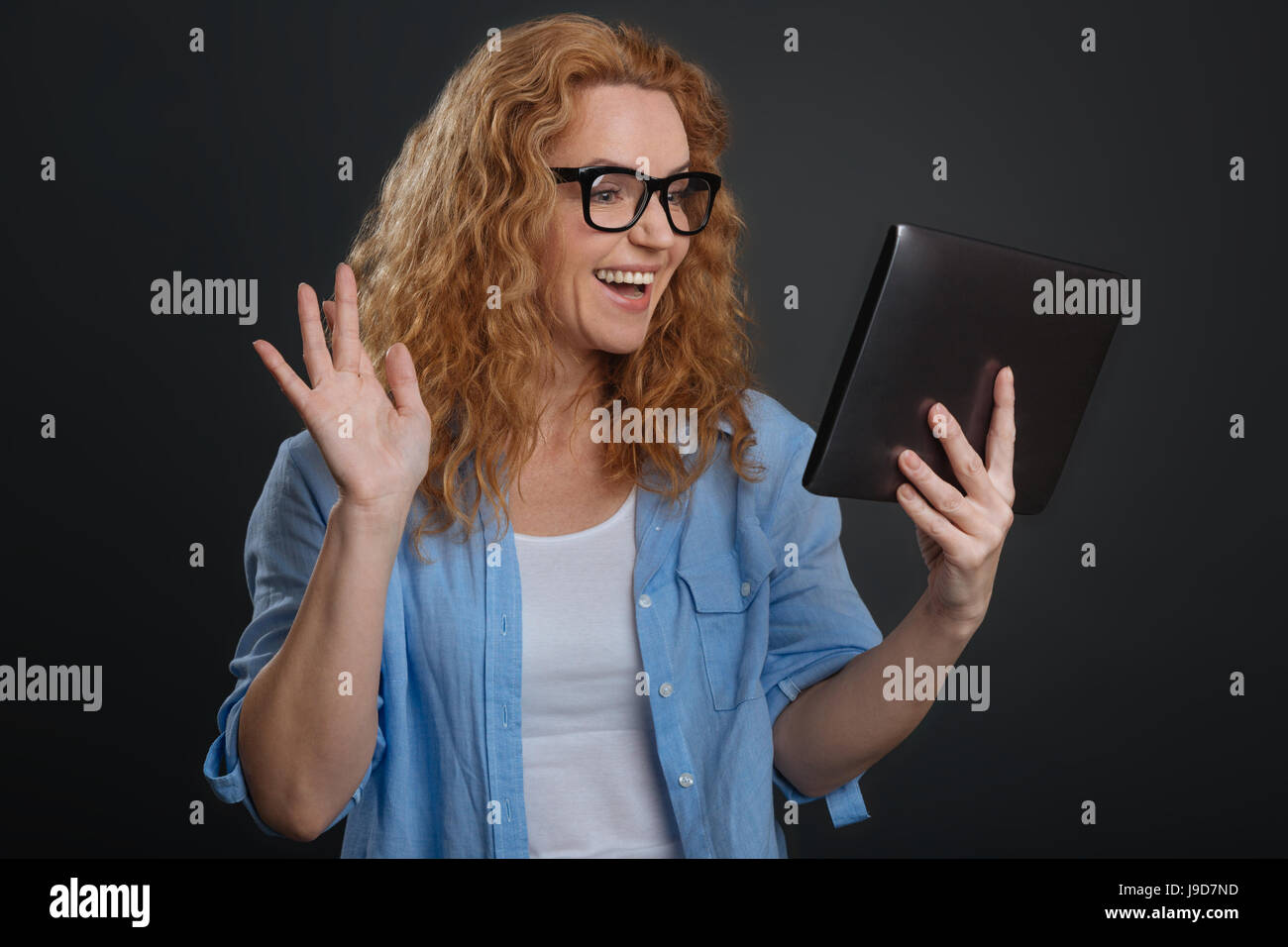 Grenzenlose Kommunikation. Nette freundliche begeistert Frau mit Hilfe moderner Technologie für ständig in Kontakt mit ihren bekannten aus aller Welt und ta Stockfoto